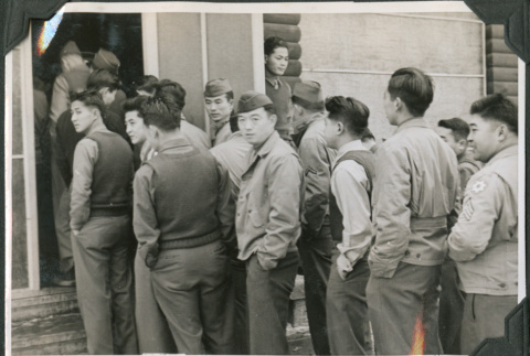 Group of men standing in line outside building (ddr-ajah-2-476)