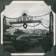 Banner over road with row of cars (ddr-ajah-2-278)