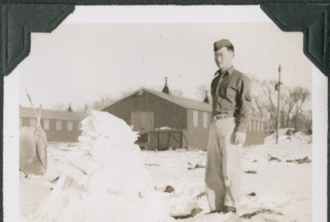 Man standing in snow by pile of snow (ddr-ajah-2-461)