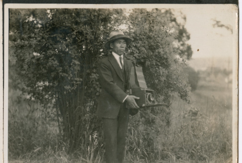 Photo of a man with a camera (ddr-densho-483-927)
