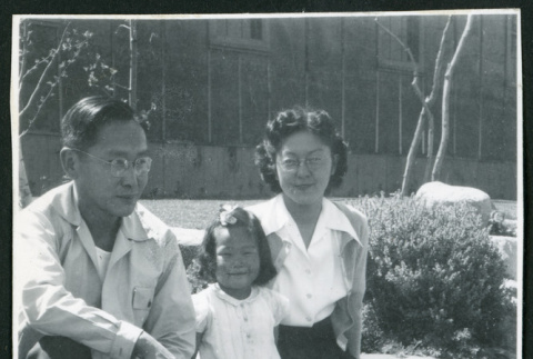 Photograph of Dr. and Mrs. Jiro Muramoto with daughter posing in front of the Manzanar hospital (ddr-csujad-47-219)