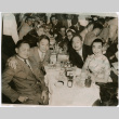 Mary Mon Toy with a large group sitting at tables (ddr-densho-367-159)