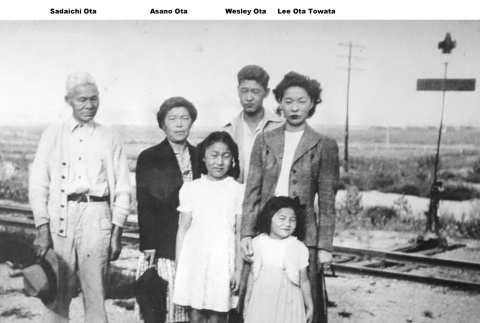 Family standing by train tracks (ddr-ajah-6-51)