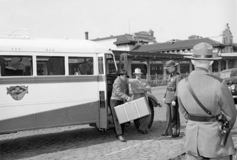 Indonesians leaving buses at the Southern Pacific depot in San Francisco, to board a train to take them to the immigration detention facility at Crystal City, Texas (ddr-csujad-27-6)