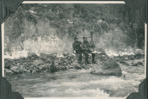 Two men crossing river on cable (ddr-ajah-2-362)