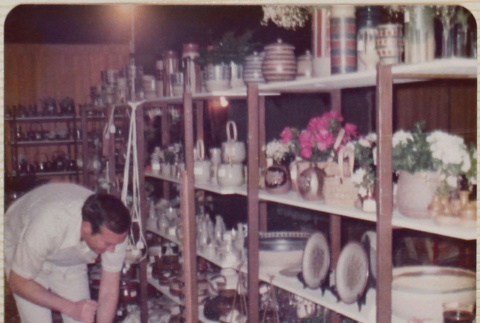 Man standing by product display shelves (ddr-densho-426-1229)