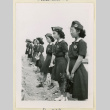 Girl Scouts stand by a row of plants (ddr-densho-37-1144)