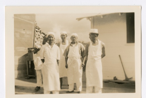 Men in white caps and aprons posing in front of a rock quarry (ddr-densho-223-35)