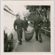 Three men in uniform carrying large sack (ddr-densho-458-34)