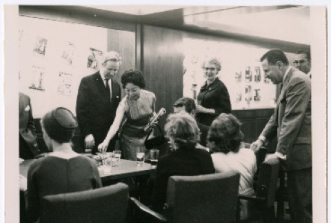 Mary Mon Toy in Esquire offices with group of people around table (ddr-densho-367-305)