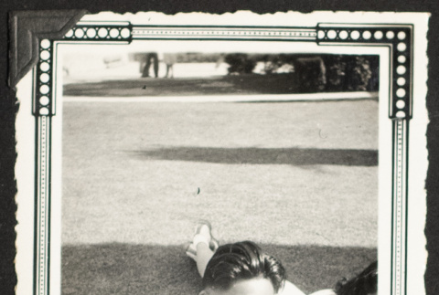Yosh and Sadako reading on a lawn (ddr-densho-542-373)