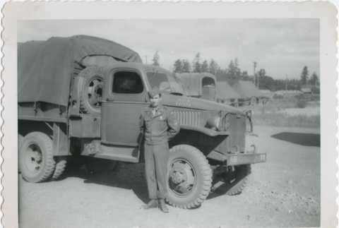 A serviceman standing next to a truck (ddr-densho-296-219)