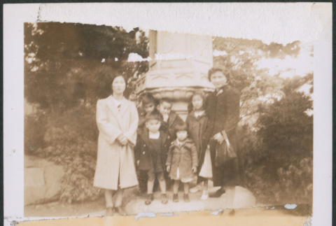 Two women and five children posing by stone pillar (ddr-densho-483-1008)