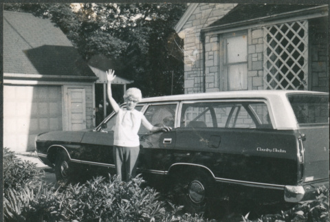 Agnes Sakura waving next to station wagon (ddr-densho-523-606)