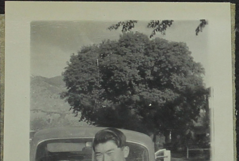 Masami Miya standing in front of a car (ddr-densho-328-544)