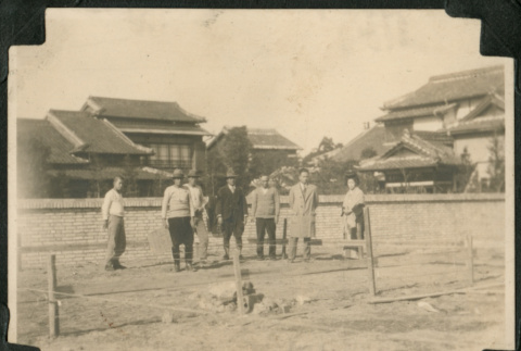 Japanese group stand in front of wall (ddr-densho-359-761)