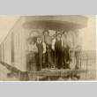 Men standing on the back of a train (ddr-densho-513-4)