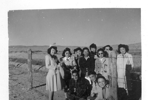 Japanese Americans next to camp fence (ddr-densho-157-28)