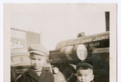 Photo of two children in overcoats on a sidewalk (ddr-densho-483-739)