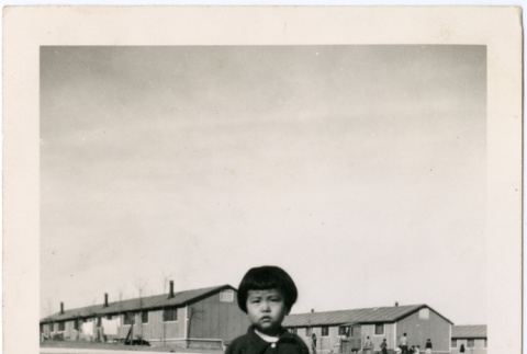 Young child standing outside barracks (ddr-densho-470-2)
