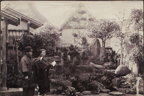Japanese man and woman reading in a garden (ddr-densho-259-238)