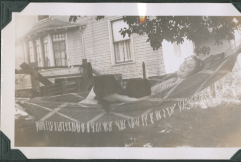 Photo of a woman in a hammock with a dog (ddr-densho-483-1203)