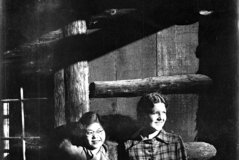 Tomoye (Nozawa) Takahashi and unknown woman standing in doorway of log house (ddr-densho-426-2021)