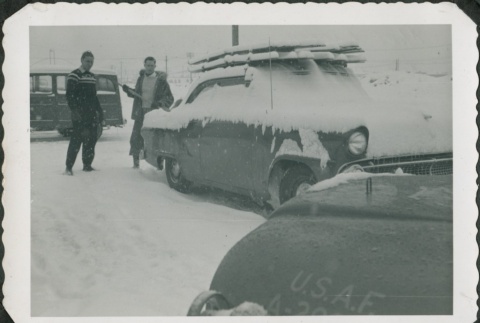 Two men shoveling ice and snow off a car (ddr-densho-321-347)