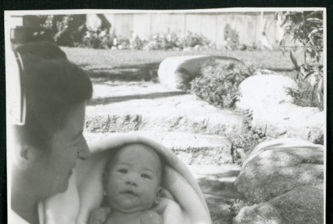 Photograph of Irene Gavigan, R.N., holding a newborn at Manzanar (ddr-csujad-47-222)