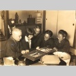 Fusetsu Nakamura looking at a photo album with his daughter and others (ddr-njpa-4-1170)