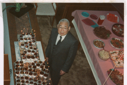 Takeo Isoshima with 75th Birthday cupcake display (ddr-densho-477-639)