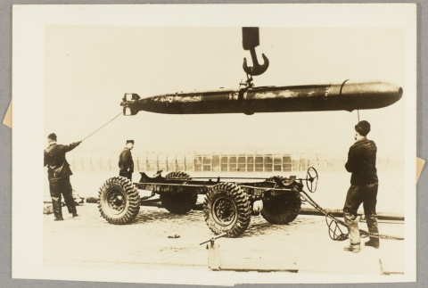 Men loading a torpedo onto trailer bed (ddr-njpa-13-986)