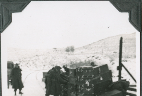 Men with pile of gear by train tracks (ddr-ajah-2-284)