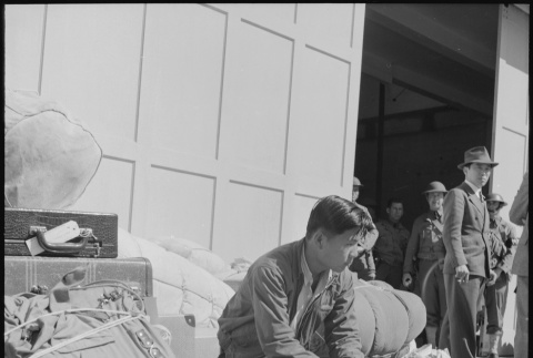 Japanese American waiting with baggage (ddr-densho-151-103)