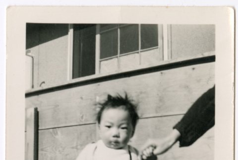 Toddler standing by barracks wall (ddr-densho-329-1338)
