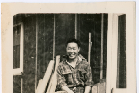 Man sitting on porch railing (ddr-densho-368-525)