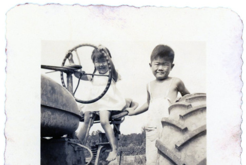 Children playing on a tractor (ddr-densho-373-68)