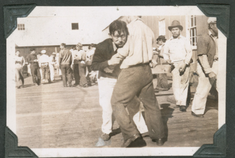 Frank Hidoka and John Kusakabe playfully fighting on boardwalk (ddr-densho-540-53)