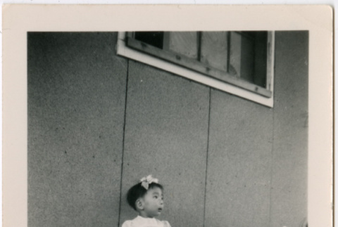 Toddler girl sitting outside barracks (ddr-densho-329-1275)