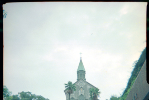 Tomoye Takahashi standing in front of Oura Church, Nagasaki (ddr-densho-426-495)