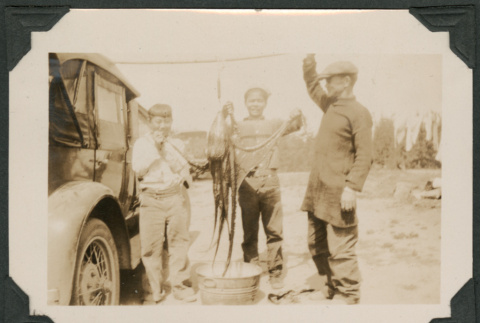 Photo of three men with an octopus (ddr-densho-483-310)