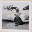 William Shiomi by car in combat helmet (ddr-densho-522-221)