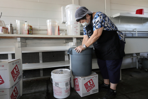 Woman preparing teriyaki sauce (ddr-densho-512-109)
