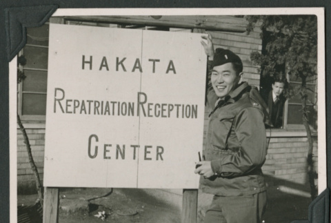 Nisei soldier poses by Repatriation Reception sign (ddr-densho-397-336)