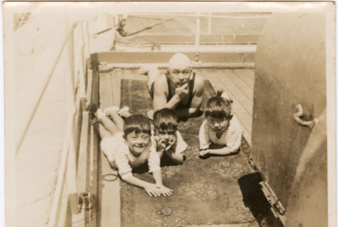 Man with three children on board ship (ddr-densho-426-1563)