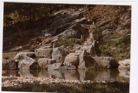 Rock wall feature by pond (ddr-densho-377-2044)
