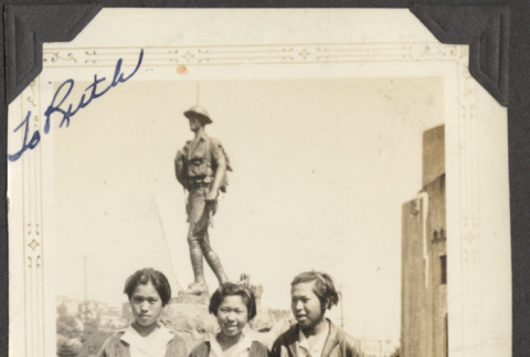 Three girls standing in front of a statue (ddr-densho-432-38)