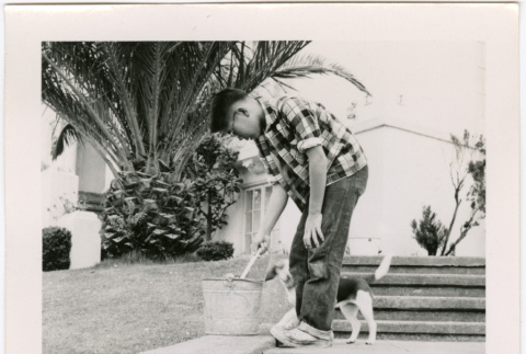 Man with dog, with bucket on stairs (ddr-densho-426-2464)
