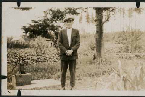 Man stands in front of farm fields (ddr-densho-359-1078)