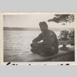 Man sitting on wall by lake (ddr-densho-466-427)